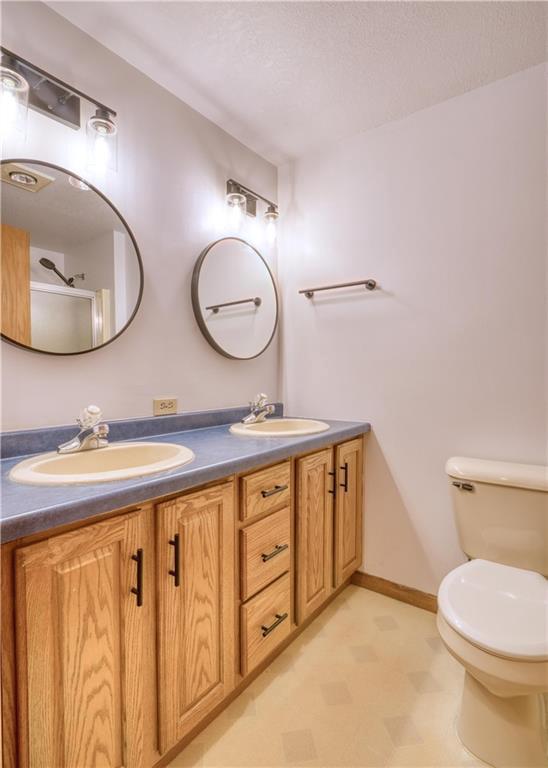 9018N Anderson Rd, Hayward, WI 54843 - bathroom with double vanity, toilet, and tile patterned floors