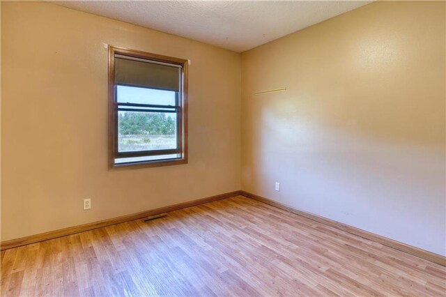 bathroom featuring a healthy amount of sunlight, a shower with shower door, hardwood / wood-style floors, toilet, and vanity