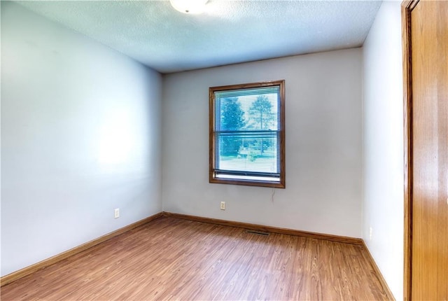 9018N Anderson Rd, Hayward, WI 54843 - empty room with light wood finished floors, baseboards, and a textured ceiling