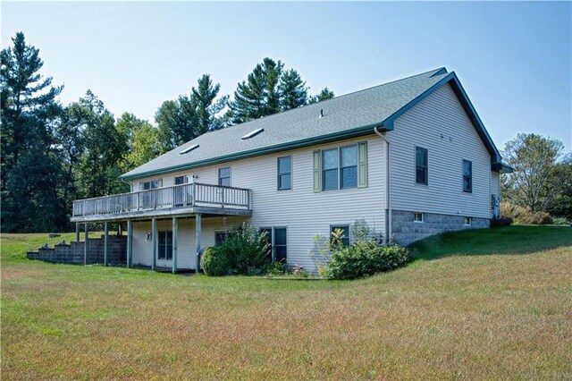 rear view of property with a yard and a deck