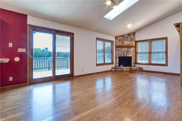 9018N Anderson Rd, Hayward, WI 54843 - unfurnished living room with plenty of natural light, wood finished floors, vaulted ceiling, and baseboards