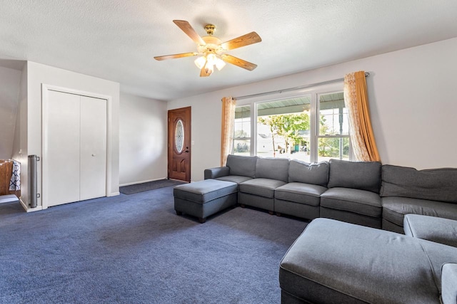 carpeted living room with a textured ceiling and ceiling fan