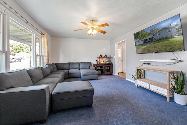 carpeted living room with ceiling fan and a textured ceiling