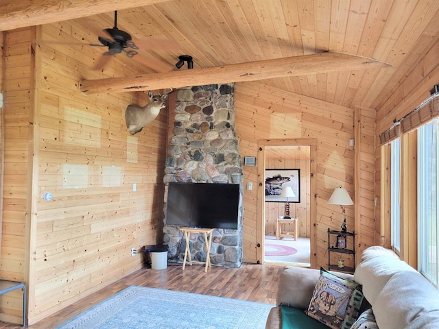 living room featuring wooden walls, ceiling fan, vaulted ceiling with beams, wood ceiling, and hardwood / wood-style flooring