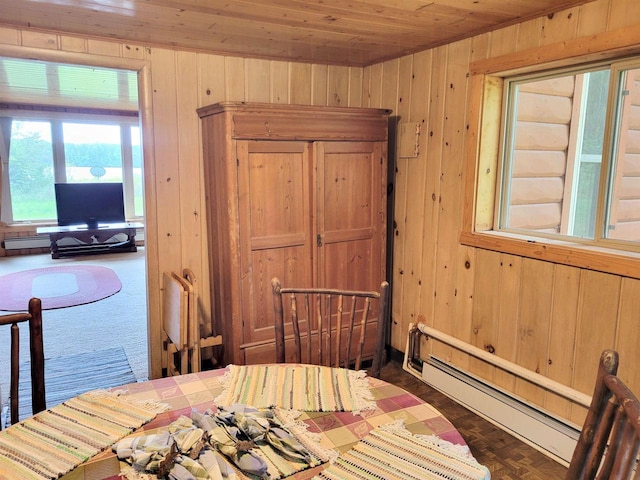 interior space featuring wood walls, wood ceiling, and a baseboard heating unit