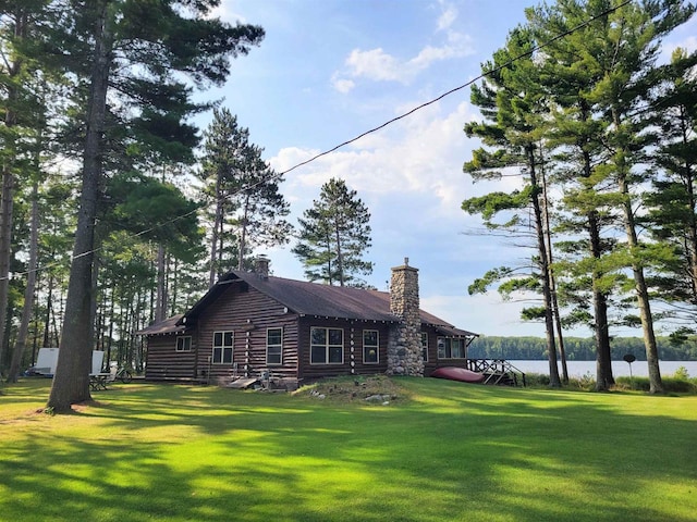 rear view of house with a yard and a water view