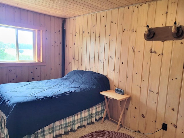 carpeted bedroom featuring wood walls and wooden ceiling