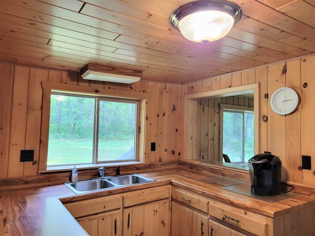 kitchen featuring light brown cabinetry, sink, wooden walls, and wooden ceiling