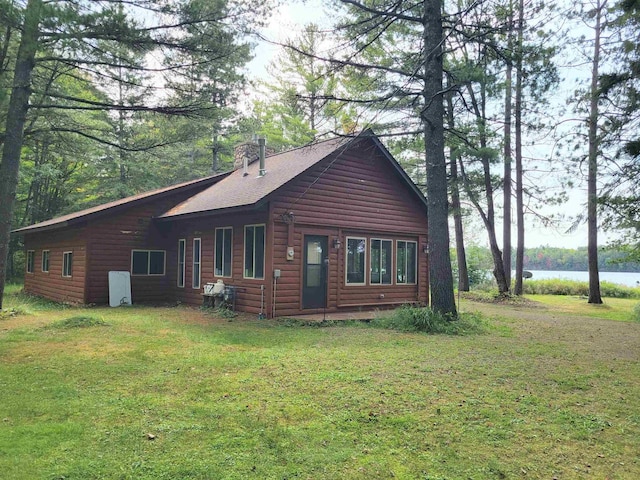 rear view of property with a water view and a yard