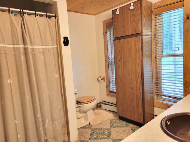 bathroom featuring a baseboard heating unit, vanity, toilet, and a wealth of natural light