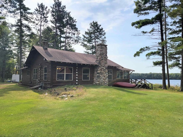 back of property featuring a water view and a yard