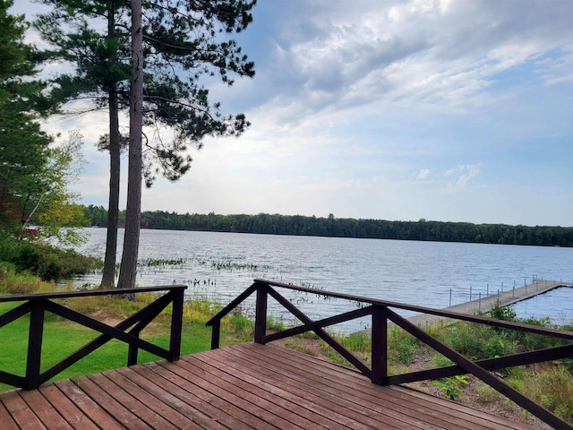 dock area with a lawn and a water view