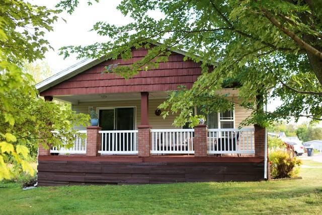 back of house featuring a yard and covered porch