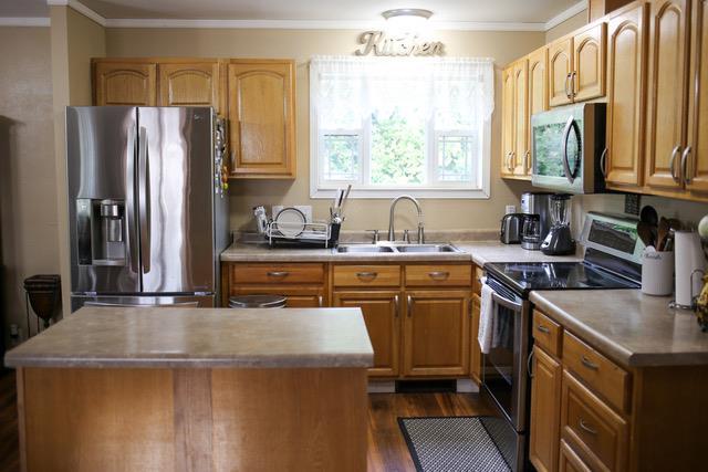 kitchen featuring dark wood-type flooring, sink, a center island, and appliances with stainless steel finishes