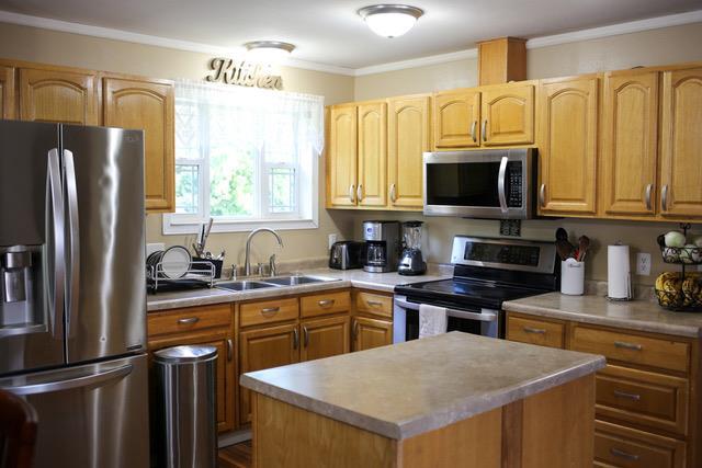 kitchen with a kitchen island, stainless steel appliances, crown molding, and sink