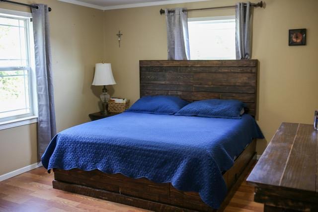 bedroom featuring ornamental molding and hardwood / wood-style floors