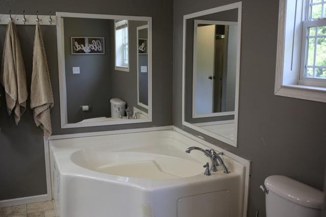 bathroom featuring toilet and a washtub