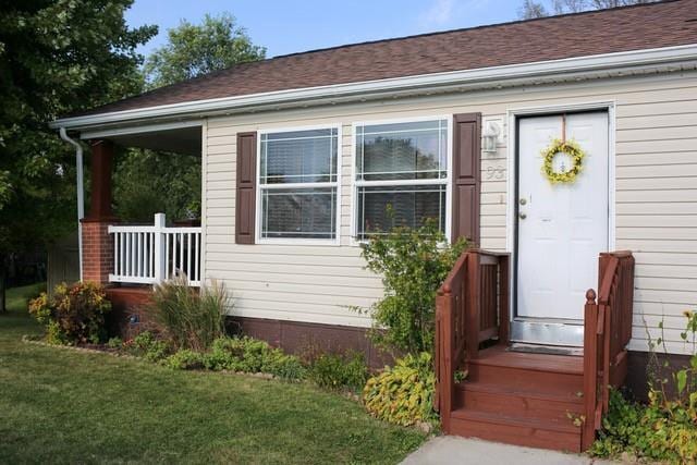 view of exterior entry featuring a yard