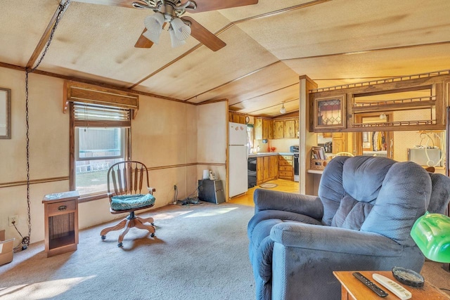 living room featuring lofted ceiling, ceiling fan, light carpet, and a textured ceiling