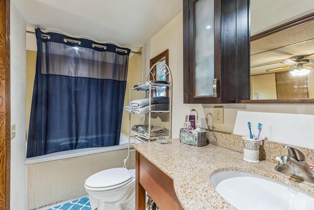 full bathroom featuring vanity, toilet, ceiling fan, and shower / bath combo with shower curtain