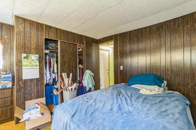 bedroom with carpet flooring, wood walls, and a closet