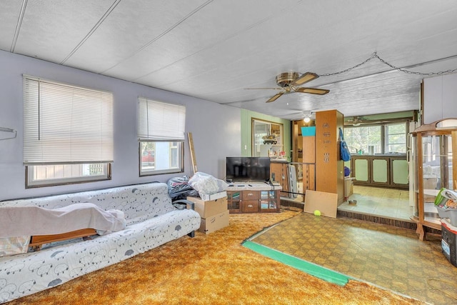 living room with a textured ceiling, a wealth of natural light, and ceiling fan