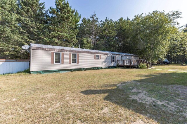 view of front of house with a front yard and a deck