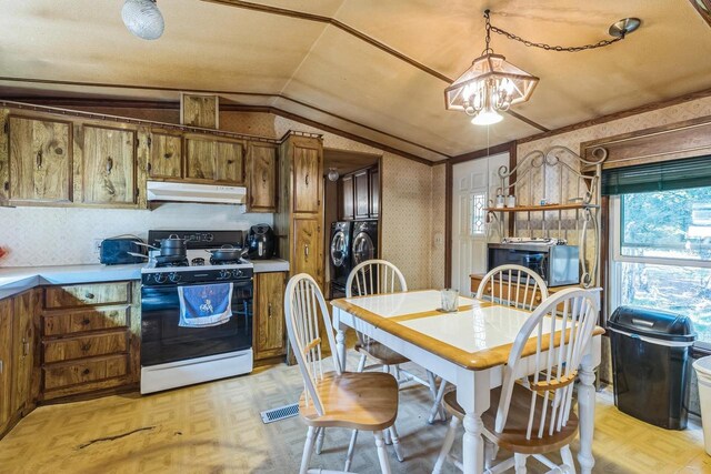 kitchen featuring pendant lighting, washer and dryer, an inviting chandelier, white gas stove, and vaulted ceiling