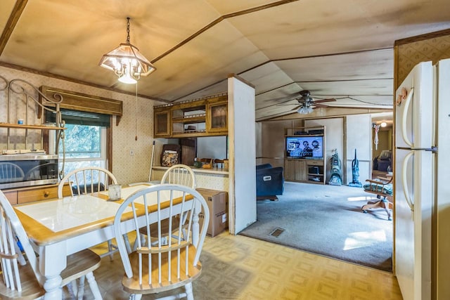 dining room with ceiling fan with notable chandelier, light parquet flooring, and lofted ceiling