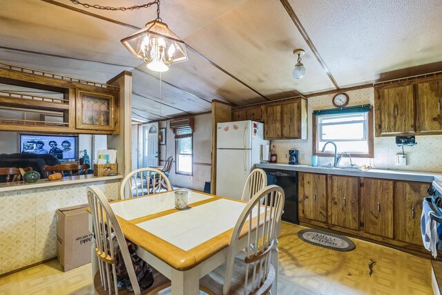 dining area with light parquet floors, a healthy amount of sunlight, an inviting chandelier, and sink