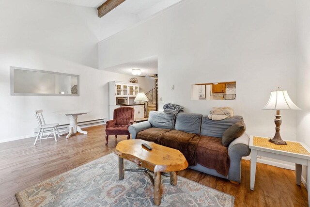 living room featuring high vaulted ceiling, wood-type flooring, and beam ceiling