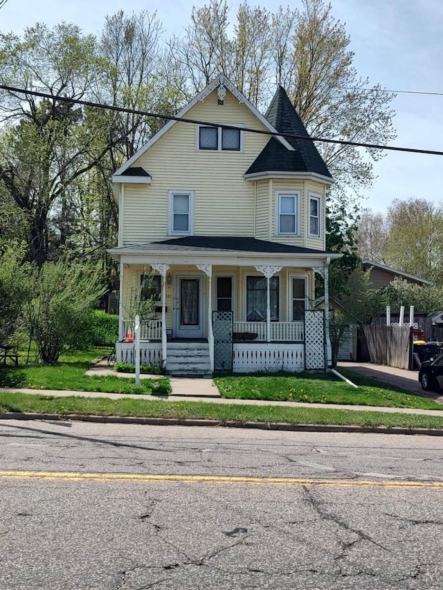 victorian-style house featuring a front lawn and a porch