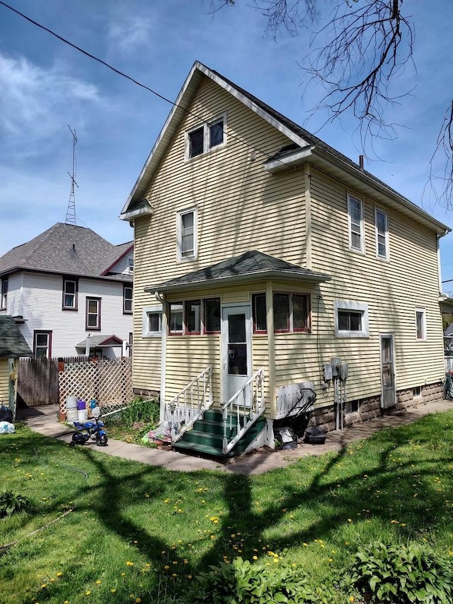 back of property featuring a lawn