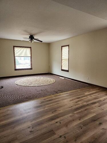 unfurnished room featuring ceiling fan and dark hardwood / wood-style flooring