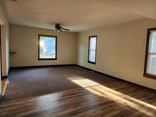 1646 Kane St, La Crosse, WI 54603 - unfurnished room featuring a healthy amount of sunlight, baseboards, ceiling fan, and wood finished floors