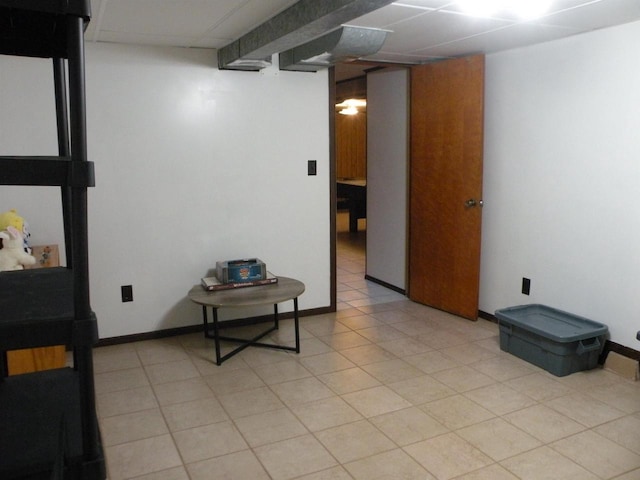 interior space with light tile patterned floors and a drop ceiling