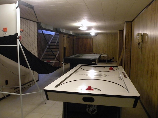 recreation room featuring wood walls and light tile patterned floors