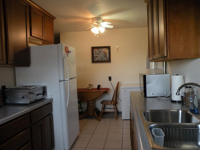 kitchen featuring ceiling fan, sink, and light tile patterned floors