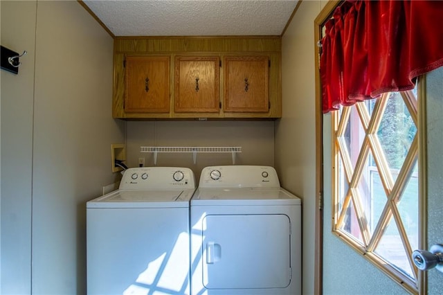 washroom featuring cabinets, a textured ceiling, and washer and dryer