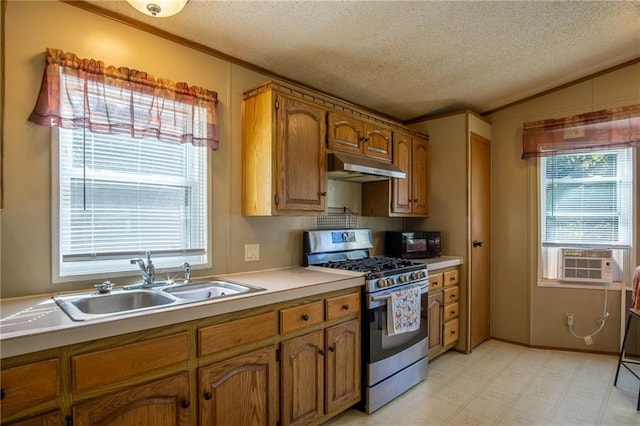 kitchen with cooling unit, a textured ceiling, stainless steel gas range oven, and sink