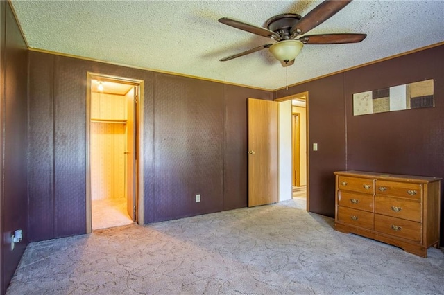 unfurnished bedroom with ceiling fan, light colored carpet, and a textured ceiling