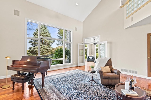 living area featuring high vaulted ceiling and hardwood / wood-style flooring