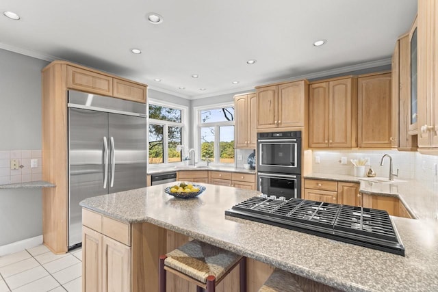 kitchen featuring appliances with stainless steel finishes, decorative backsplash, a breakfast bar area, and sink