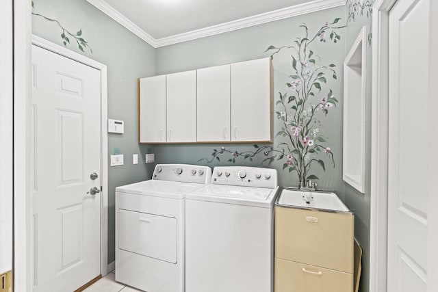 clothes washing area with cabinets, light tile patterned flooring, washer and dryer, and crown molding