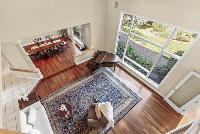 living room featuring hardwood / wood-style flooring, a towering ceiling, and plenty of natural light