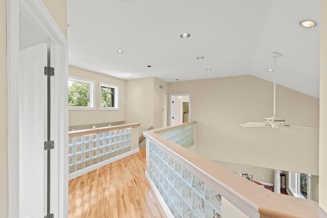 hall featuring light hardwood / wood-style flooring and lofted ceiling