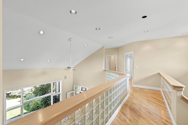 hallway with light hardwood / wood-style floors and lofted ceiling