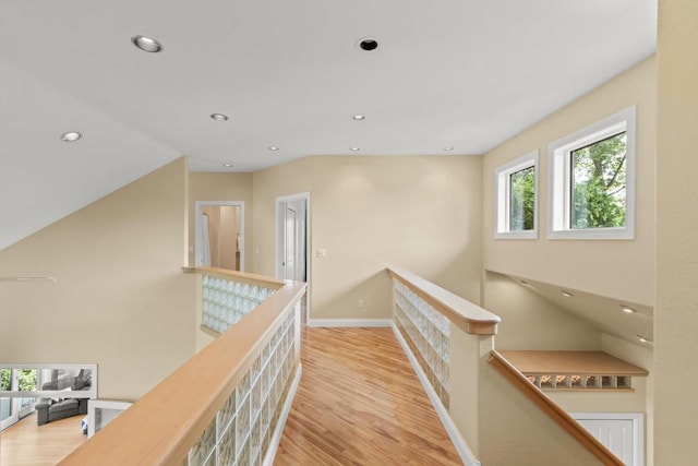 hall with light wood-type flooring and a healthy amount of sunlight