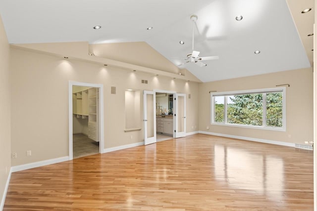 unfurnished living room with high vaulted ceiling, ceiling fan, and light hardwood / wood-style flooring