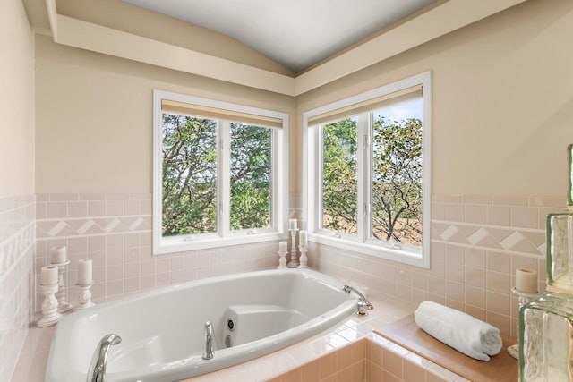 bathroom with vaulted ceiling and a relaxing tiled tub